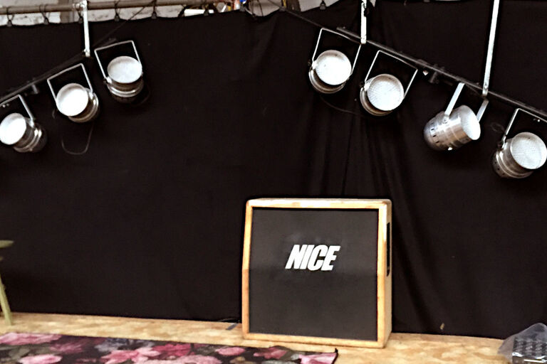 Unter zwei Scheinwerferbaterien steht ein Schild mit der Aufschrift "NICE"