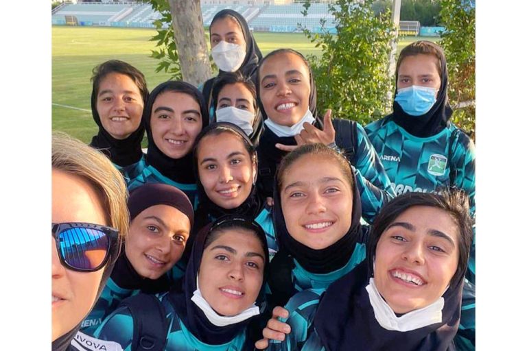 Gruppenselfie der Manschaft aus jungen Frauen, die in ihren einheitlichen Trainingsanzügen in die Kamera lachen