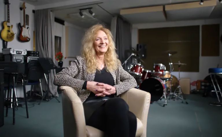 Tina Powileit sitzt in einem Sessel in einem Musikstudio.
