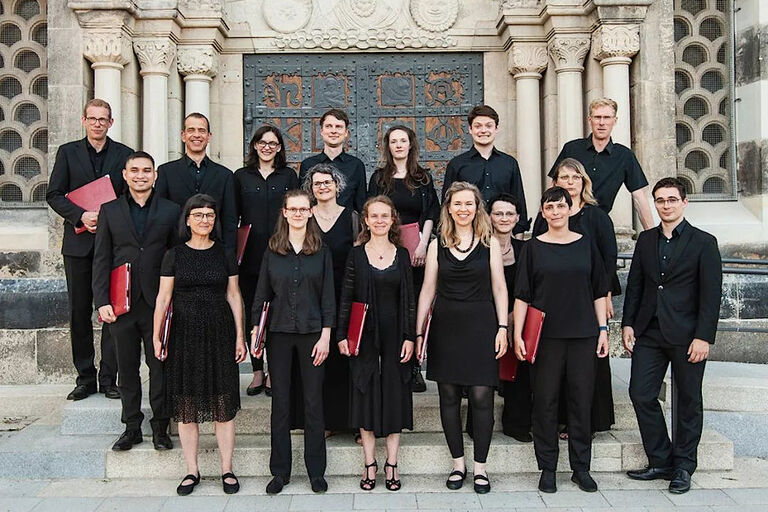 Gruppenfoto des Ensemble TonART in schwarzer Kleidung vor einem Kirchenportal