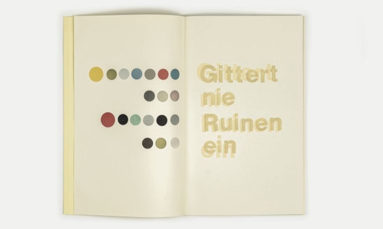 Blick auf eine Doppelseite in einem Buch, mit dem Text "Gittert nie Ruinen ein" auf der einen und farbigen Kreisflächen auf der anderen Seite