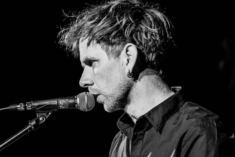 Nahaufnahme des Musikers in schwarz-weiß vor einem Mikrofon