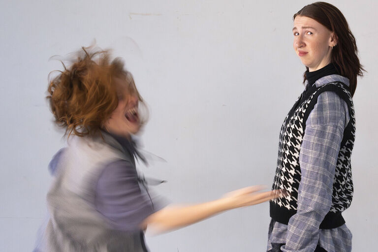 Zwei Frauen stehen sich gegenüber - die eine gestikuliert wild und die andere schaut skeptisch zur Seite
