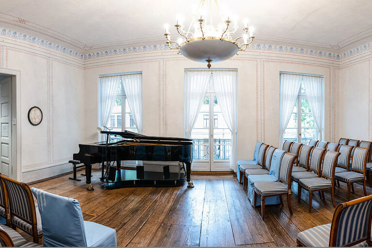 Der historische Schumann-Saal mit alten Holzdielen Stuhlreihen und einem Konzertflügel