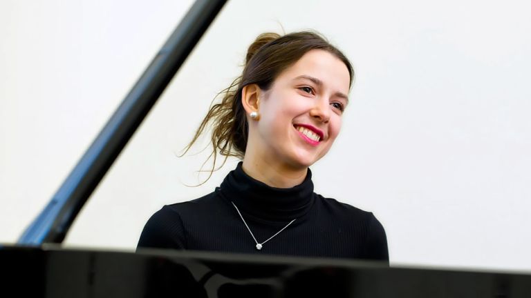 Foto der lächelnden Pianistin am Konzertflügel