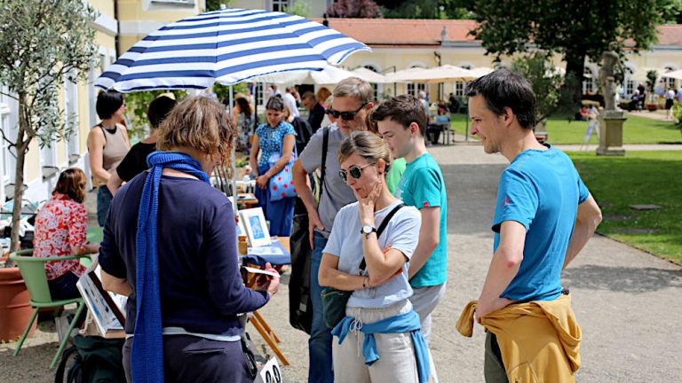 Im Garten des Gohliser Schlösschens sind viele Stände aufgebaut umd die sich interessierte Besucherinnen und Besucher drängen.