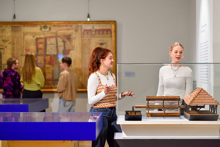 Zwei Frauen stehen in der Ausstellung vor einer Vitrine mit dem Modell einer Schiffsmühle