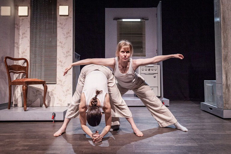 Zwei Tänzerinnen auf der Bhne - im Hintergrund die Kulisse einer altmodischen Küche