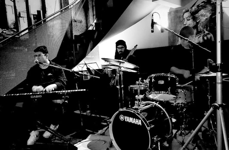 Schwarz-Weiß-Foto der Band bei einem Konzert in einem kleinen Klub