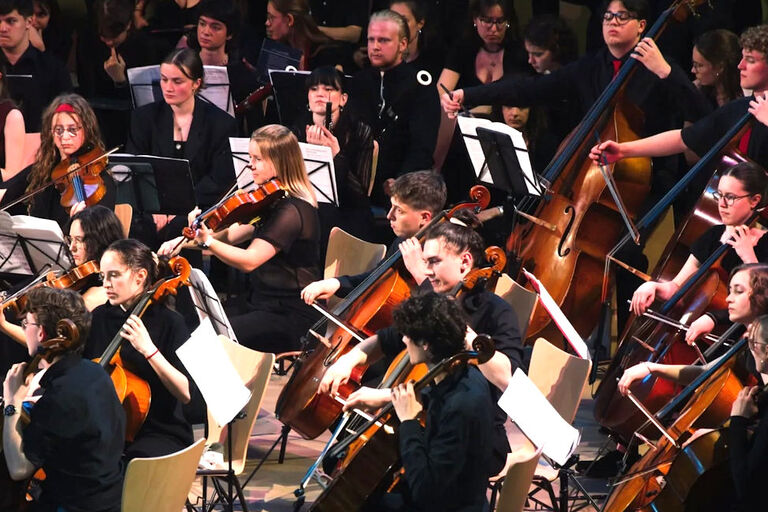 Foto der sitzenden Musikerinnen und Musiker bei einem Konzert