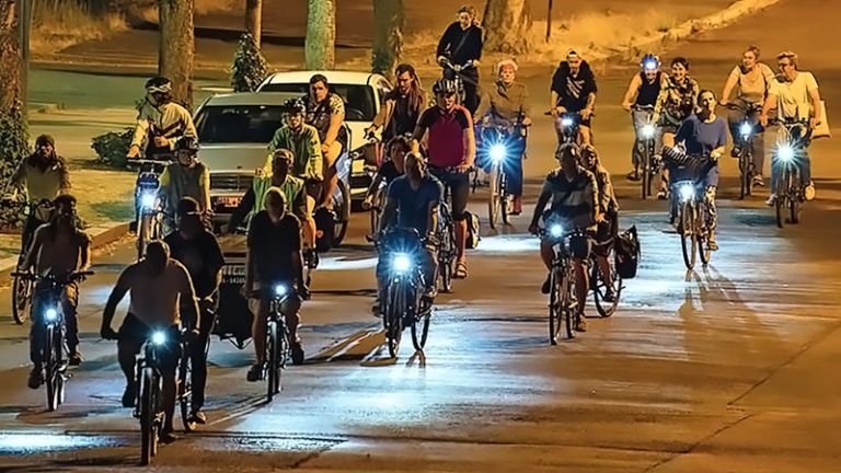 Ein Pulk von Radfahrern radelt nachts durch die Stadt.