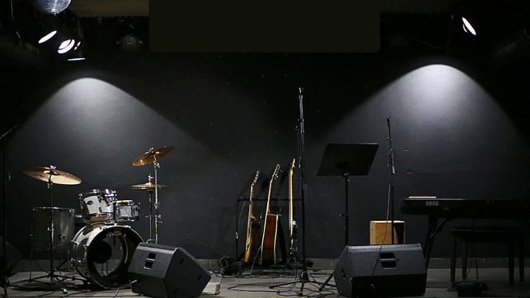 Foto der Bühne im Villakeller mit Schlagzeug, Gitarren, Mikrofonen und einem Keyboard