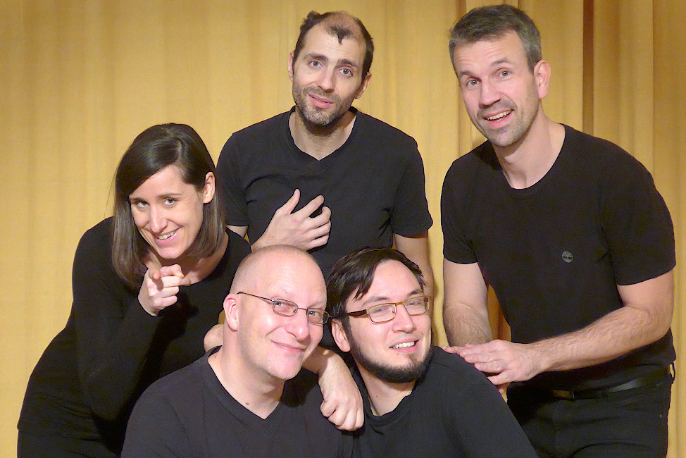 Gruppenfoto der Schauspielerinnen und Schauspieler in unterschiedlichen theatralischen Posen