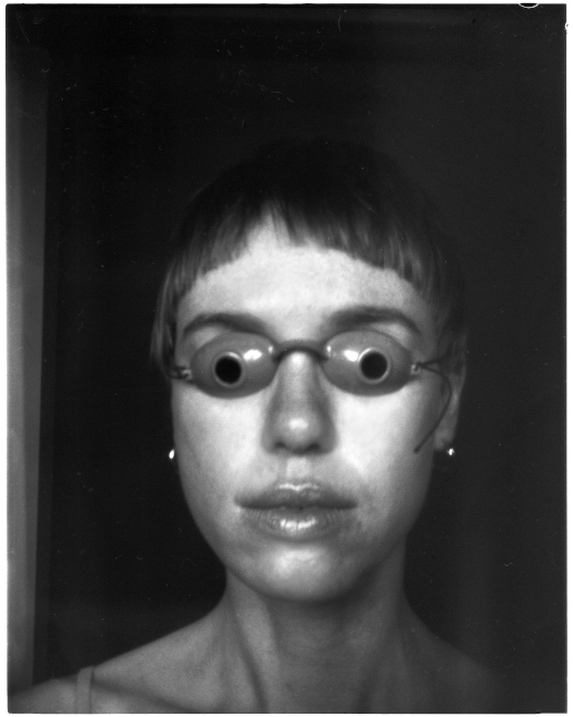 Schwarz-Weiß-Foto einer Person mit einer Brille, die wie Augen geformt ist