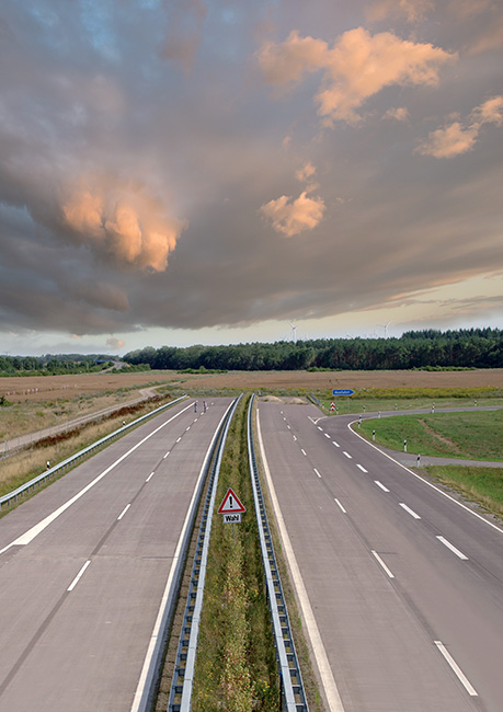 Foto einer unfertigen Autobahn, die in einem Feld endet.