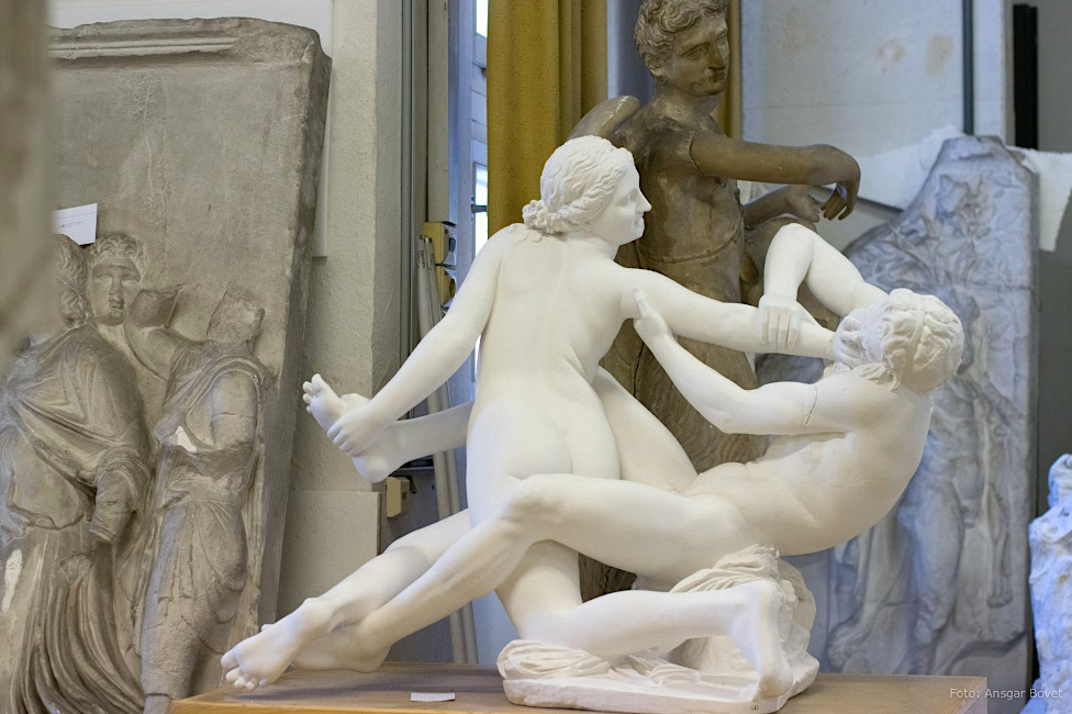 Eine antike Skulptur zeigt zwei Personen, die zu kämpfen scheinen