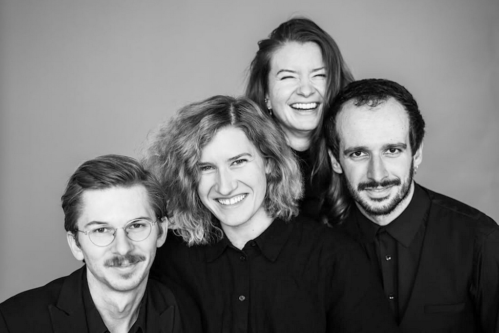 Gruppenfoto der lachenden Musikerinnen und Musiker in schwarz-weiß