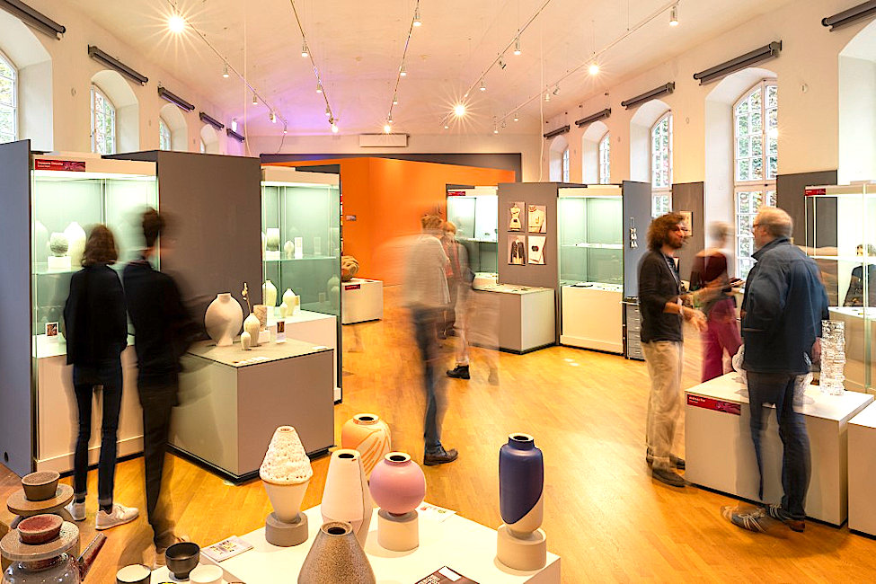 Blick in einen Ausstellungsraum der Grassimess mit Besuchern, Ständen und Vitrinen