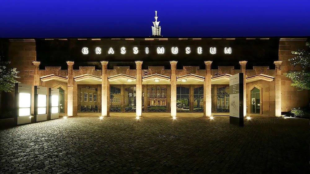 Das festlich erleuchtete Portal des GRASSI Museums bei Nacht