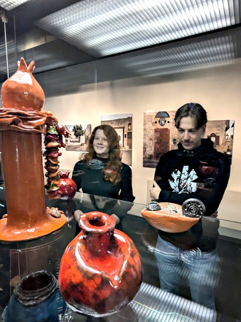 Besucher stehen vor einer Vitrine mit keramischen Gefäßen.