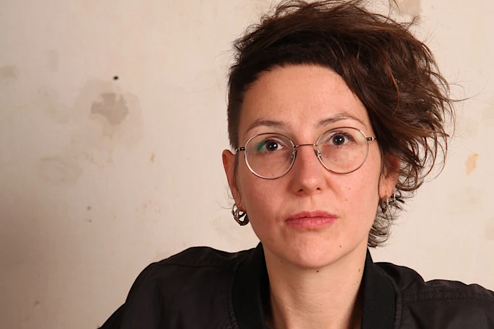 Portraitfoto von Jule Govrin mit Nickelbrille und hochgesteckten Haaren