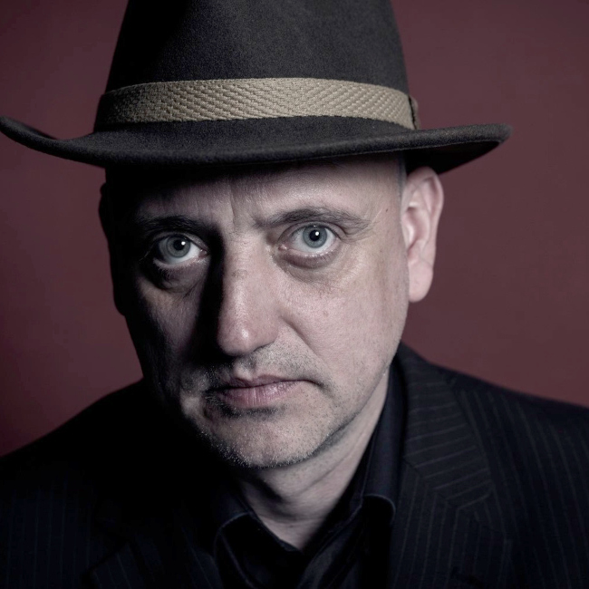 Portraitfoto des ernst blickenden Kai-Uwe Kohlschmidts mit Hut