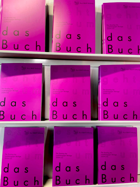 In einem Regal stehen die neuen Kataloge der Kurt-Wolf-Stiftung nebeneinander.