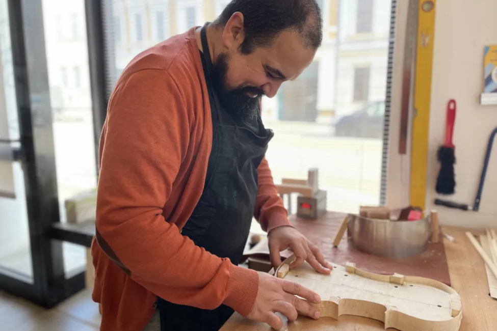 Der Geigenbauer arbeitet an eiem Tisch am Korpus eines neeuen Instruments.