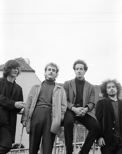 Gruppenfoto der Band im Freien vor einem Geländer