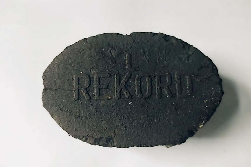Ein ovales Kohlebrikett, auf das das Wort Rekord geprägt wurde
