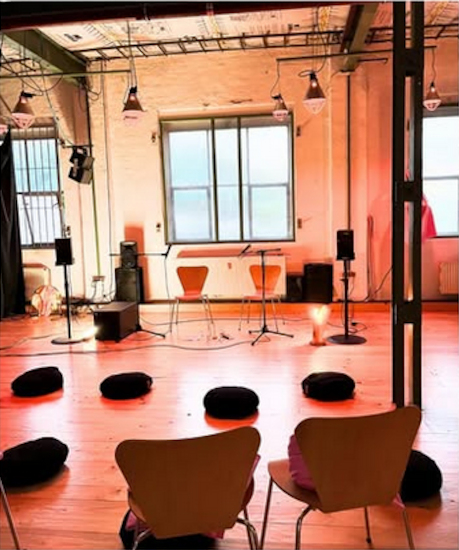 In einem großen Raum sind Stühle und Sitzkissen verteilt worden.