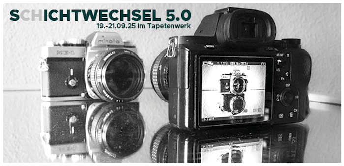 Zwei Fotoapparate stehen sich auf einem Spiegel gegenüber, wobei im Display das einen der andere Apparat zu sehen ist.