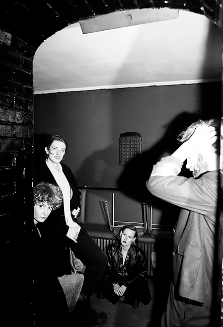 Schwarz-Weiß-Foto der Band in einem leeren und düsteren Kellerraum