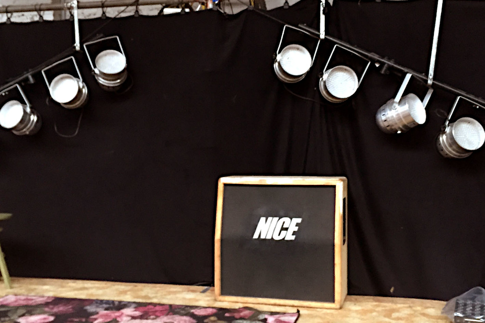 Unter zwei Scheinwerferbaterien steht ein Schild mit der Aufschrift "NICE"