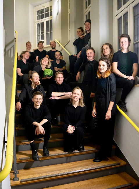 Gruppenfoto des Chors in schwarzer Kleidung in einem Treppenhaus